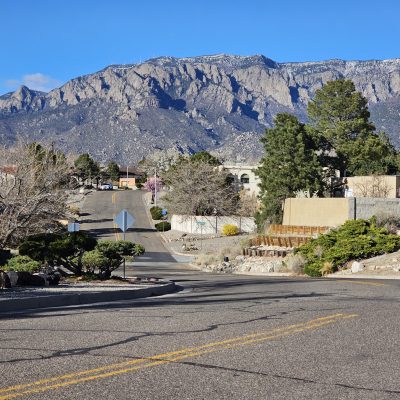 Neighborhood street with mountain view in background.