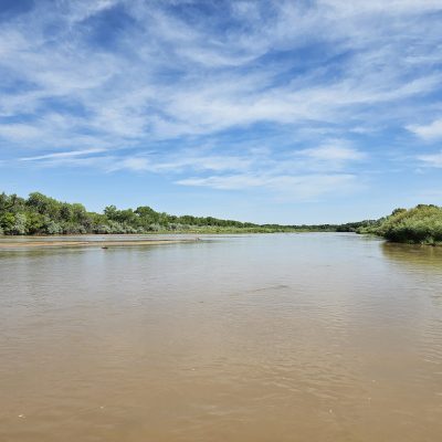 River with trees and cloudy blue sky