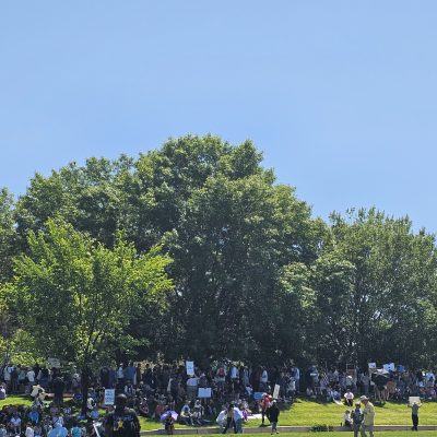 Group gathering at park under trees.