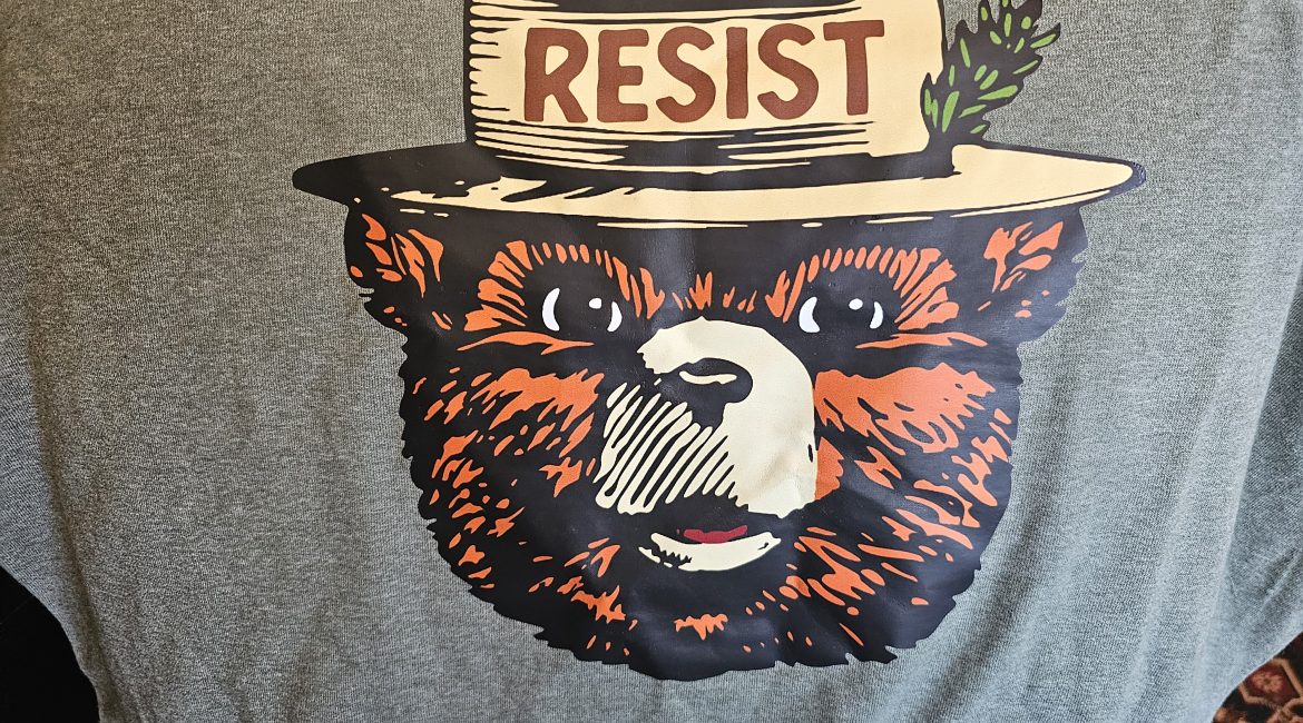 Smokey Bear t-shirt with 'Resist' text on hat.