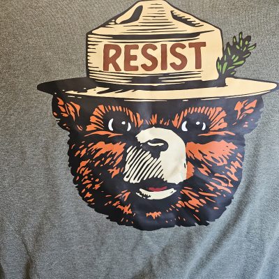 Smokey Bear t-shirt with 'Resist' text on hat.