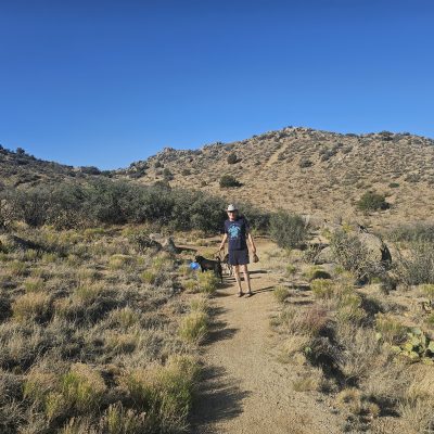 Man walking dog on desert trail