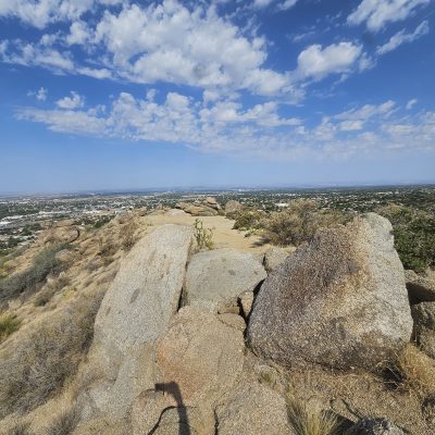 Rocky hillside overlooking distant town and sky