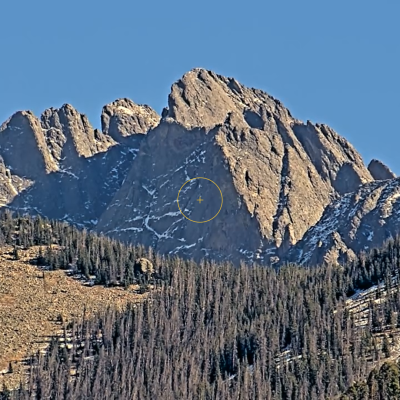 Rocky mountain peak with forested slopes.